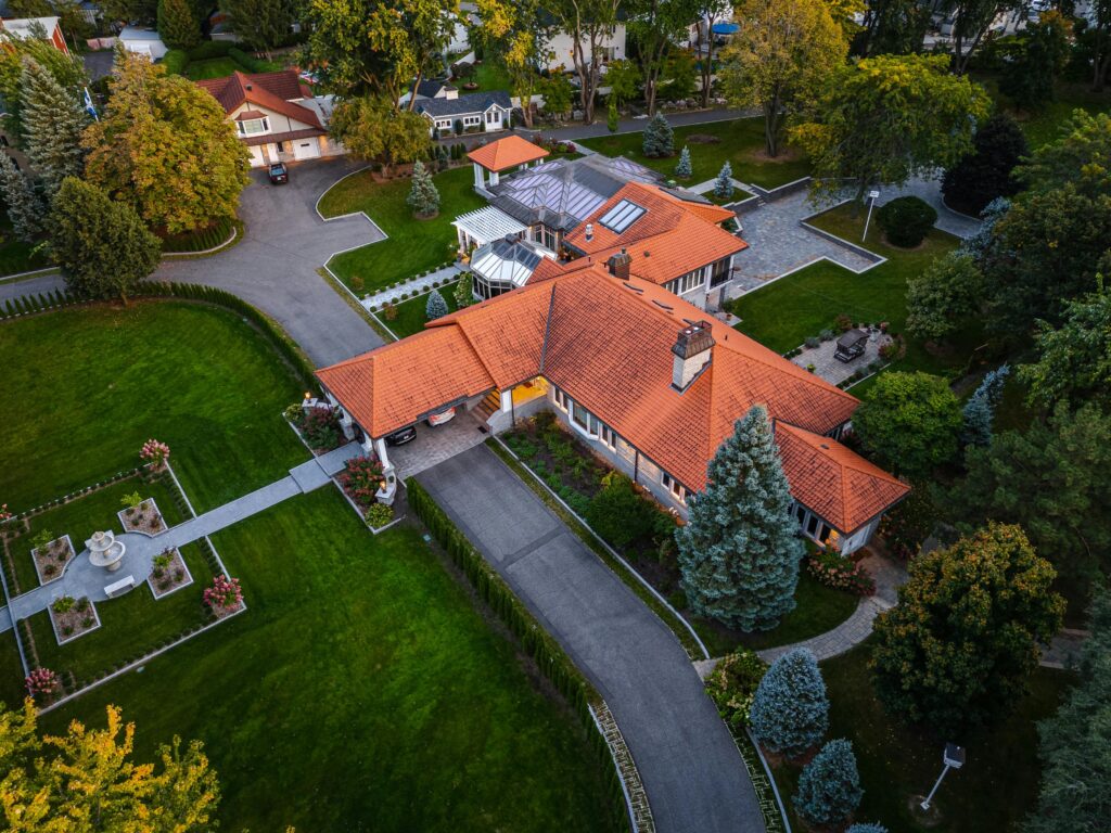 Drone shot capturing a luxurious estate with orange roof in Saint-Jean-sur-Richelieu, Canada.